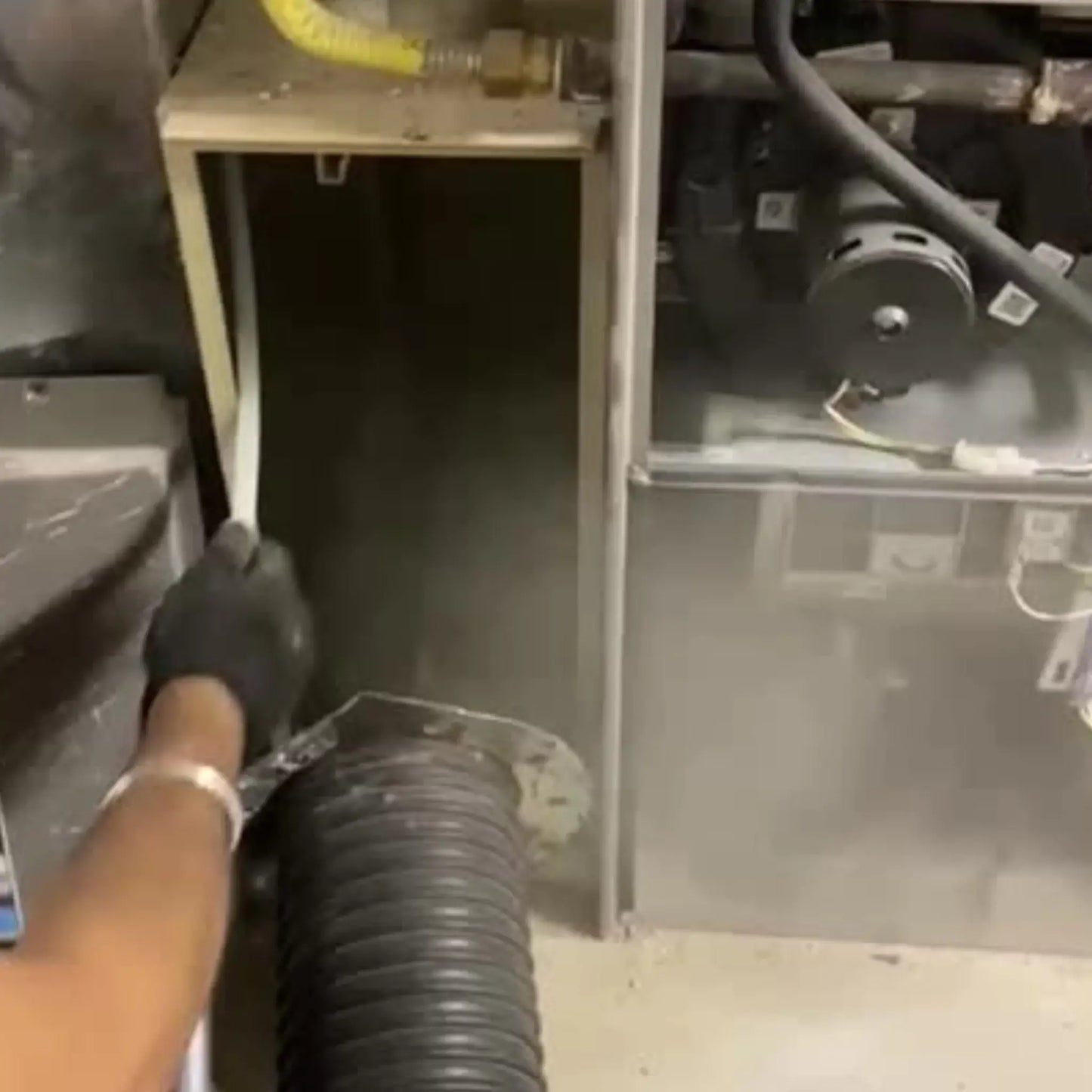 Image showing Furnace Cleaning Cleaning of residential Furnace with powerful suction and blowing. Lot of dust and contamination can be seen. Job performed by Power HVAC Services technician.