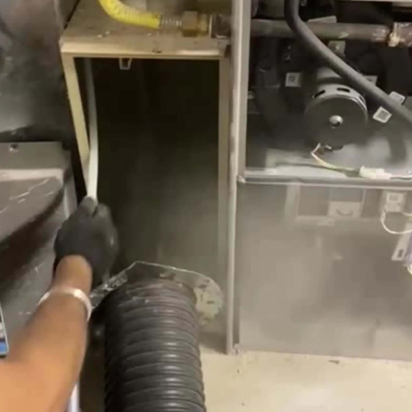 Image showing Furnace Cleaning Cleaning of residential Furnace with powerful suction and blowing. Lot of dust and contamination can be seen. Job performed by Power HVAC Services technician.