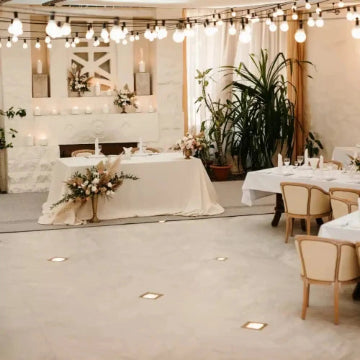 Experience an elegant wedding reception setup in the GTA with neatly arranged tables and chairs, string lights, decorated settings, and potted plants. Enjoy a seamless experience complemented by Power HVAC Services innovative robot-assisted commercial air duct cleaning.