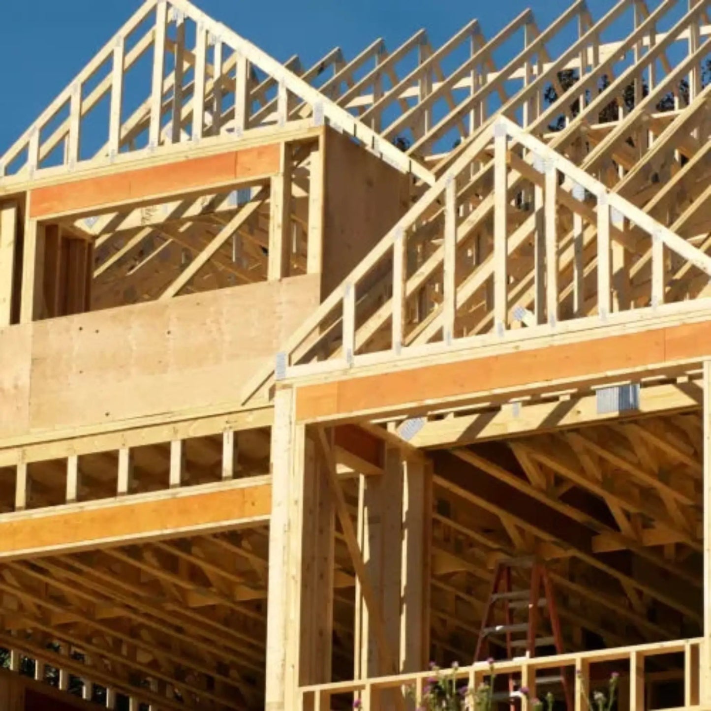 The wooden framework of a two-story house under construction displays intricate trusses with a ladder inside. Nearby in GTA, Power HVAC Services Commercial Air Duct Cleaning ensures pristine air quality for residential and commercial spaces using robot-assisted technology. Call us for pre-construction or post-construction air duct cleaing services.