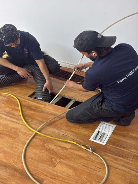 Power HVAC technicians cleaning a residential floor air duct